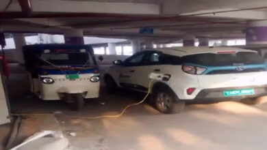 Employees charge electric cars in multilevel parking